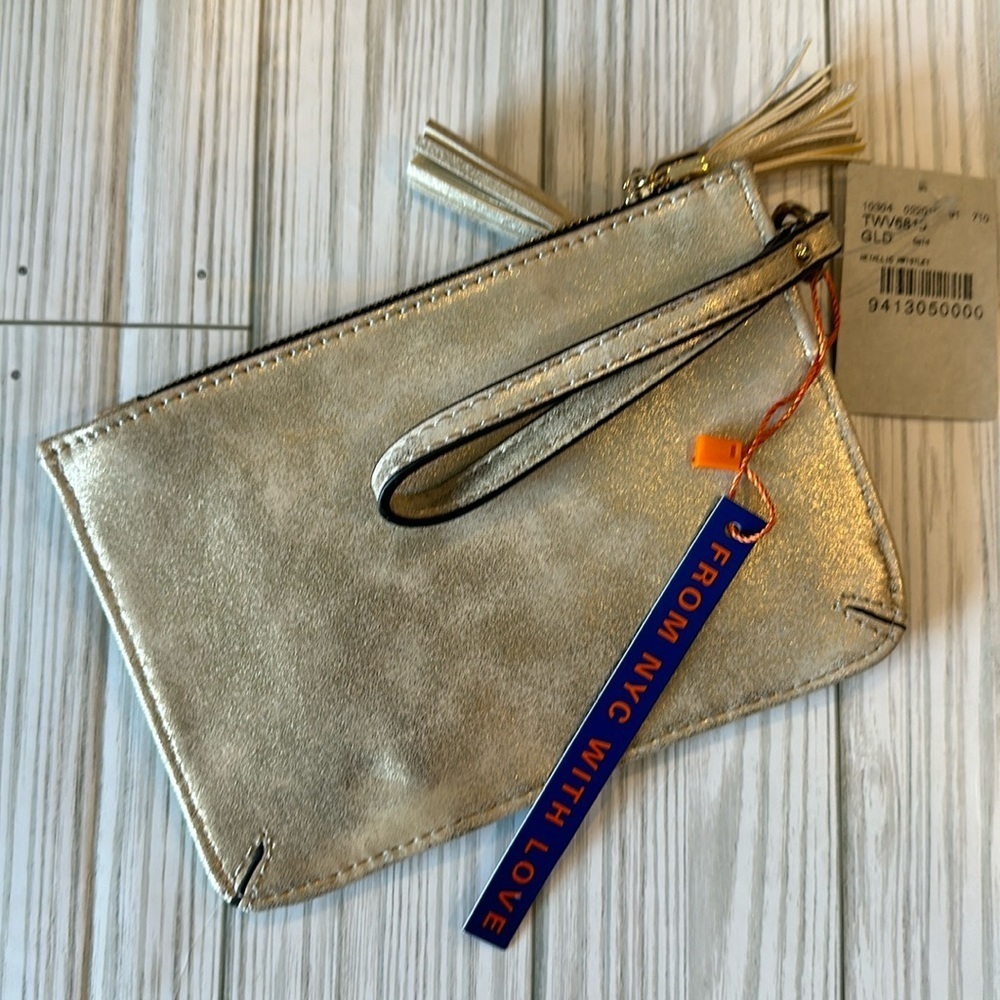 Buckle NWT metallic gold wristlet with tassels on zippers.